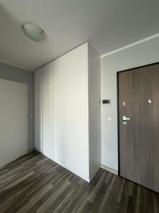 an empty room with a door and a wooden floor at Apartament Marco z balkonem in Oleśnica
