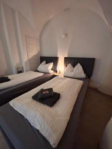 two beds in a room with a hat on them at Ferienwohnung Paulick I Zentrales Altstadt Apartment I Garten Terrasse Grill I 2 Schlafzimmer in Bautzen