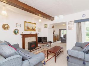 a living room with blue chairs and a fireplace at Symbister Suite in Turriff