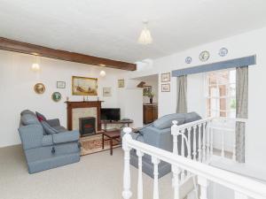 a living room with two chairs and a fireplace at Symbister Suite in Turriff