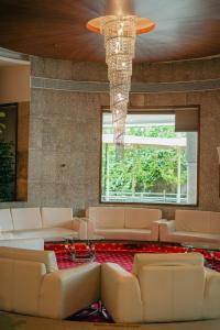 a living room with white couches and a chandelier at Peninsula Grand in Mumbai