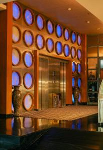 a lobby with a bunch of circular windows and a counter at Peninsula Grand in Mumbai