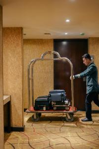 a man pushing a cart with luggage at Peninsula Grand in Mumbai