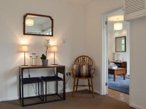 a room with a table and a mirror and a chair at Sea Breezes in Totland