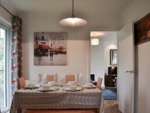 a dining room with a table with plates and bowls at Sea Breezes in Totland