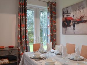 a dining room with a table and a window at Sea Breezes in Totland
