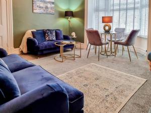 a living room with a blue couch and chairs at Jack's House- Uk40741 in Tywyn