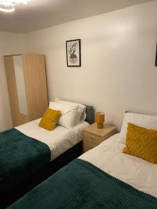 a bedroom with two beds and a mirror at Charming Contractors & Family Friendly 3-BR House in Harlow, Essex in Great Parndon