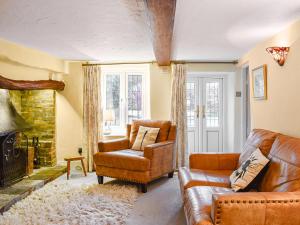 a living room with a couch and a chair at Flanders Cottage in Lymington