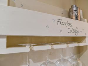 a shelf with wine glasses and a sign on it at Flanders Cottage in Lymington +16 photos