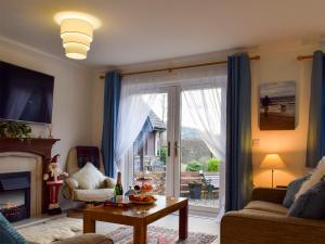 a living room with a large sliding glass door at Dream Cottage in Strathyre