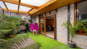 a house with a green yard with palm trees in it at Sumitel Shangrila in Tādong
