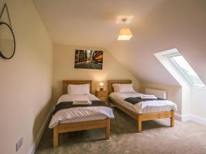 two twin beds in a attic room with a window at 2 Dawson Court - Uk33411 in Mablethorpe +2 photos