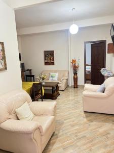 a living room with white couches and a table at ES Berat Apartments in Berat