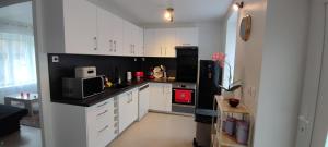 a kitchen with white cabinets and a red appliance at Bienvenue chez Céline in Mareuil-sur-Ourcq +8 photos
