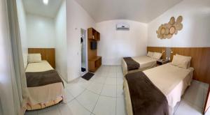 a hotel room with two beds in a room at Vila Lençóis Residence in Santo Amaro +76 photos