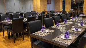 a room with tables and chairs with purple napkins on them at Sumitel Shangrila in Tādong