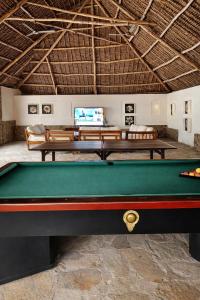 a pool table in a living room with a tv at Lawford Apartment Malindi in Malindi