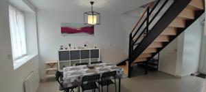 a dining room with a table and chairs and a staircase at Bienvenue chez Céline in Mareuil-sur-Ourcq
