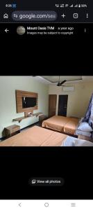 a screenshot of a hotel room with a bed and a tv at MOUNT OASIS RESIDENCY Tiruvannamalai in Tiruvannāmalai