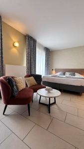 una stanza con un letto, un divano e un tavolo di Hotel José a Blankenberge