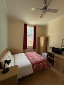 a bedroom with a bed and a window with red curtains at European Hotel in London +20 photos