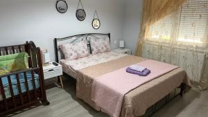 a bedroom with a bed with pink sheets and a crib at JennyHouse in Drama