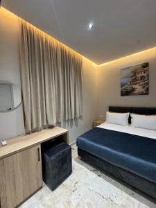 a hotel room with a bed and a television at Alesia's Guesthouse in Vlorë