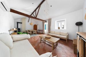 a living room with white furniture and a table at Casa Flor de Sal in Moncarapacho