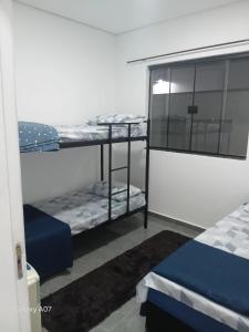 a room with two bunk beds and a window at Casa nova, completa, 3 quartos 1 com ar condicionado in Hortolândia