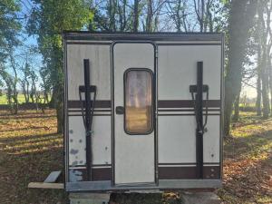 a trailer with the door open in a field at L insolite in Maxent