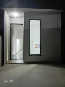 an empty room with a mirror and a hallway at Casa nova, completa, 3 quartos 1 com ar condicionado in Hortolândia