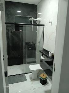 a bathroom with a toilet and a glass shower at Casa nova, completa, 3 quartos 1 com ar condicionado in Hortolândia +15 photos