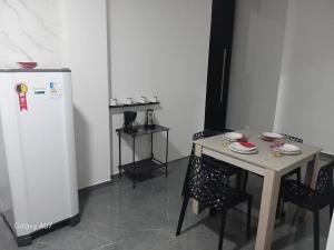 a kitchen with a table and a white refrigerator at Casa nova, completa, 3 quartos 1 com ar condicionado in Hortolândia