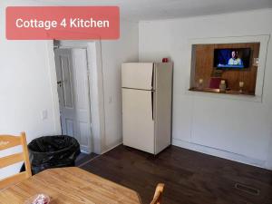 a kitchen with a white refrigerator and a table at Cottage 4 Duplex In Eckman ATV Fun and Rentals! in Northfork