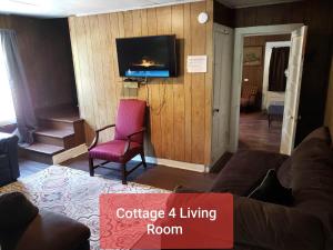 a living room with a couch and a tv at Cottage 4 Duplex In Eckman ATV Fun and Rentals! in Northfork