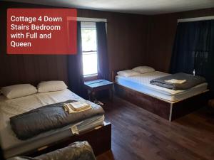 a room with two beds and a sign that reads cuddle down starts bedroom at Cottage 4 Duplex In Eckman ATV Fun and Rentals! in Northfork