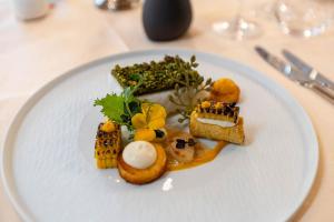 a white plate with food on a table at Boutique Hotel Römerhof - Charme und Genuss am Bodensee in Arbon