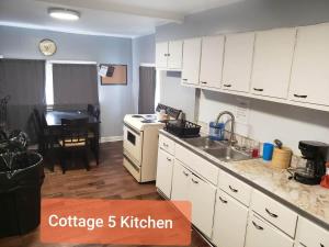 a kitchen with white cabinets and a sink and a stove at Cottage 5 Duplex in Eckman ATV Fun and Rentals! in Northfork