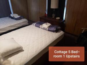 two twin beds in a room with a sign that says conference bed room at Cottage 5 Duplex in Eckman ATV Fun and Rentals! in Northfork +8 photos