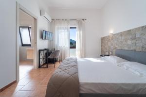 a bedroom with a bed and a room with a table at Albergo Ristorante Locanda Rosella in Giba