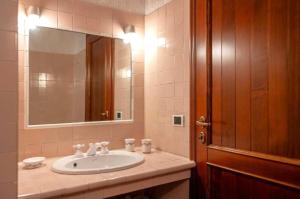 a bathroom with a sink and a mirror at Casa C'era una volta in Costa Volpino +20 photos