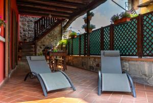 a patio with two chairs and a table and a table at Casa C'era una volta in Costa Volpino