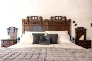 a bedroom with a large bed with a wooden headboard at Casa C'era una volta in Costa Volpino