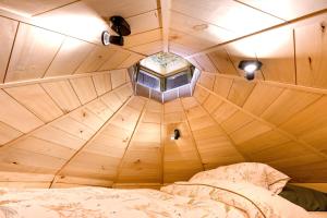 a small room with a bed in a wooden ceiling at Les insolites de la Ferme de Froidefontaine in Havelange