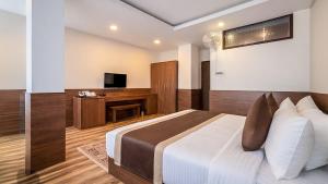 a bedroom with a large bed and a television at Sumitel Shangrila in Tādong