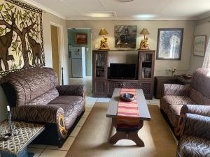 a living room with two couches and a coffee table at Bohemian Garden Cottages in Kaapsehoop