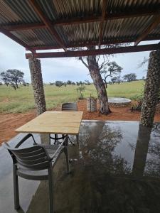 a wooden table and chairs under a wooden roof at Troupant - Luxury Bush Unit in Askham