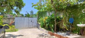 a garden with a fence and a sink at Kemmiu single room in São Tomé