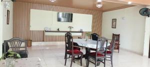 a dining room with a table and four chairs at Kemmiu single room in São Tomé